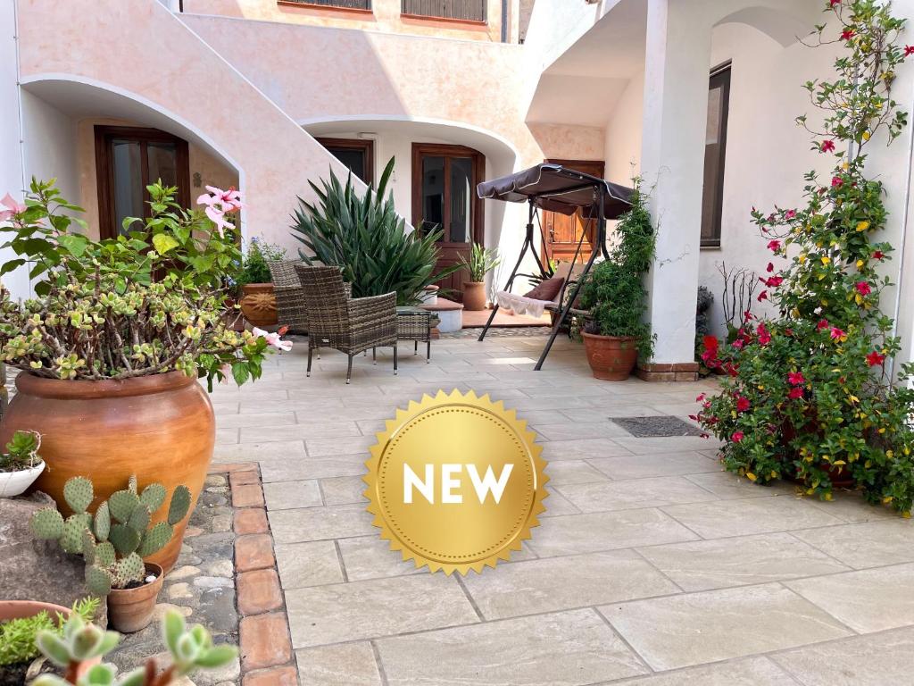 een nieuw bord op een patio met planten bij Casa Lia - Independent apartment in the Gulf of Orosei in Galtellì