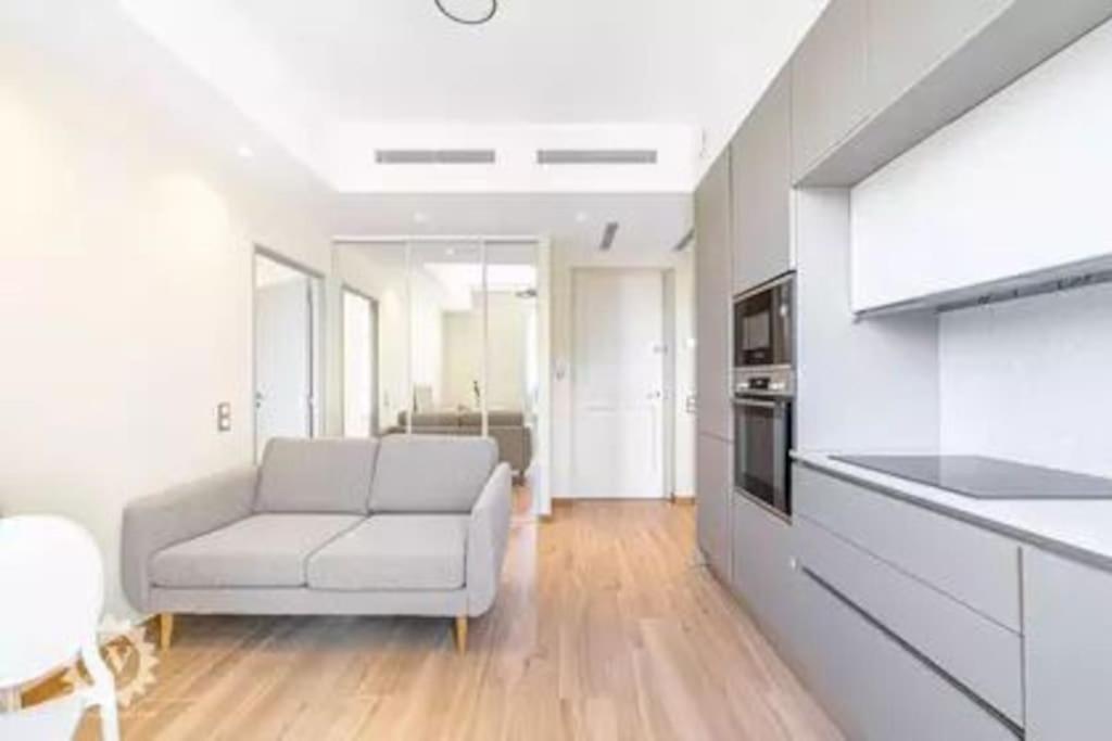 un salon avec un canapé et une cuisine dans l'établissement Bright, newly renovated apartment, à Nice