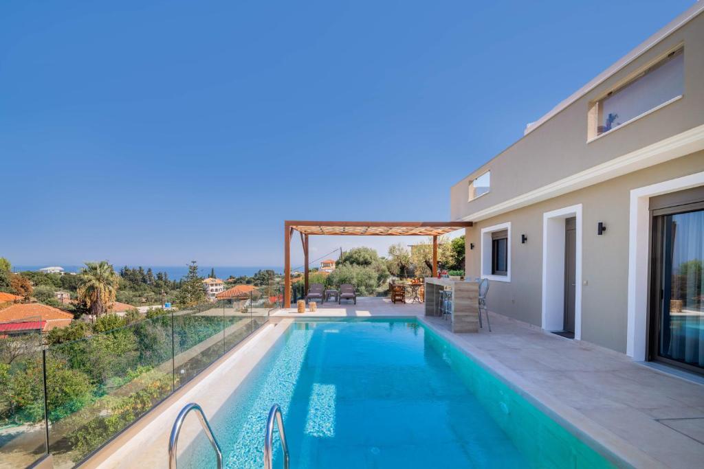 a swimming pool with a view of a house at Lazai Villa in Zakynthos