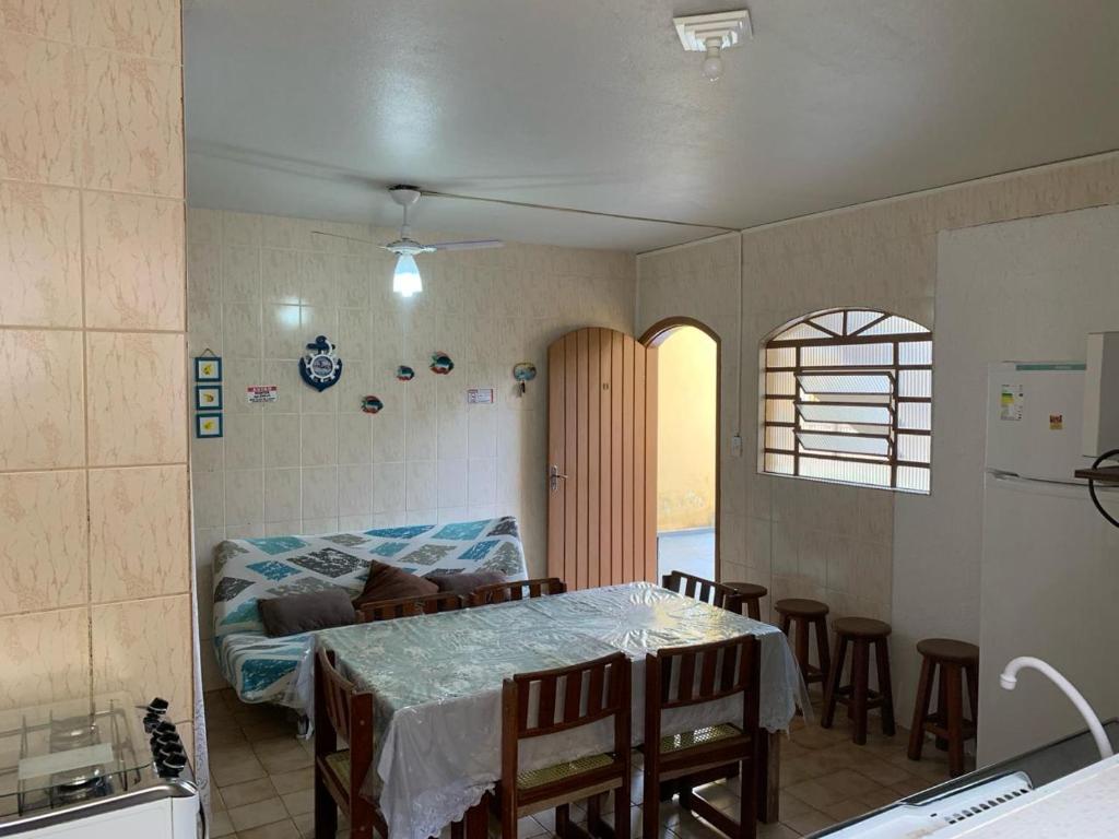 um quarto com uma cama e uma mesa com cadeiras em Ubatuba - apenas 5 minutos á pé até a praia em Ubatuba