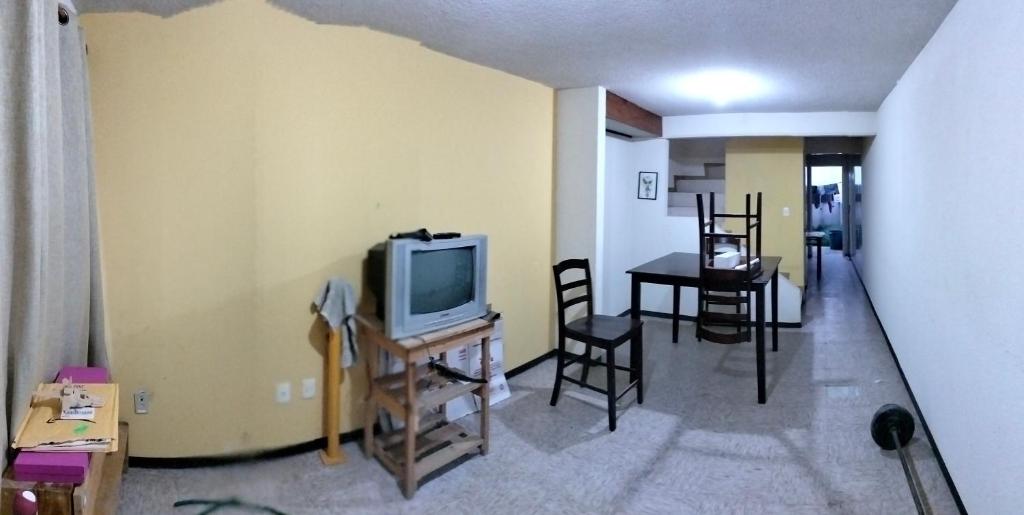 a living room with a television and a table with chairs at Casita bonita in San Gregorio Cuautzingo