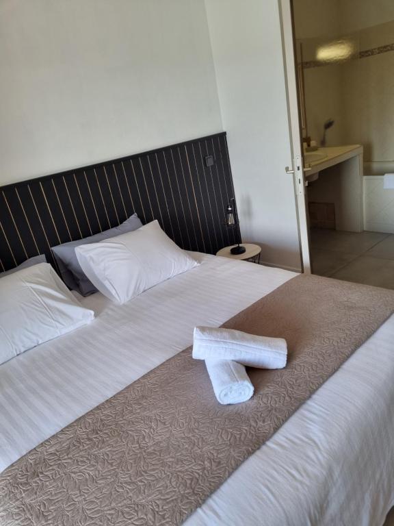 a white towel sitting on top of a bed at Auberge des Salles in Les Salles-sur-Verdon