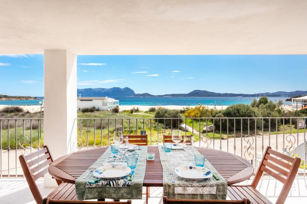 a table on a balcony with a view of the ocean at Vista mozzafiato fronte mare in Olbia