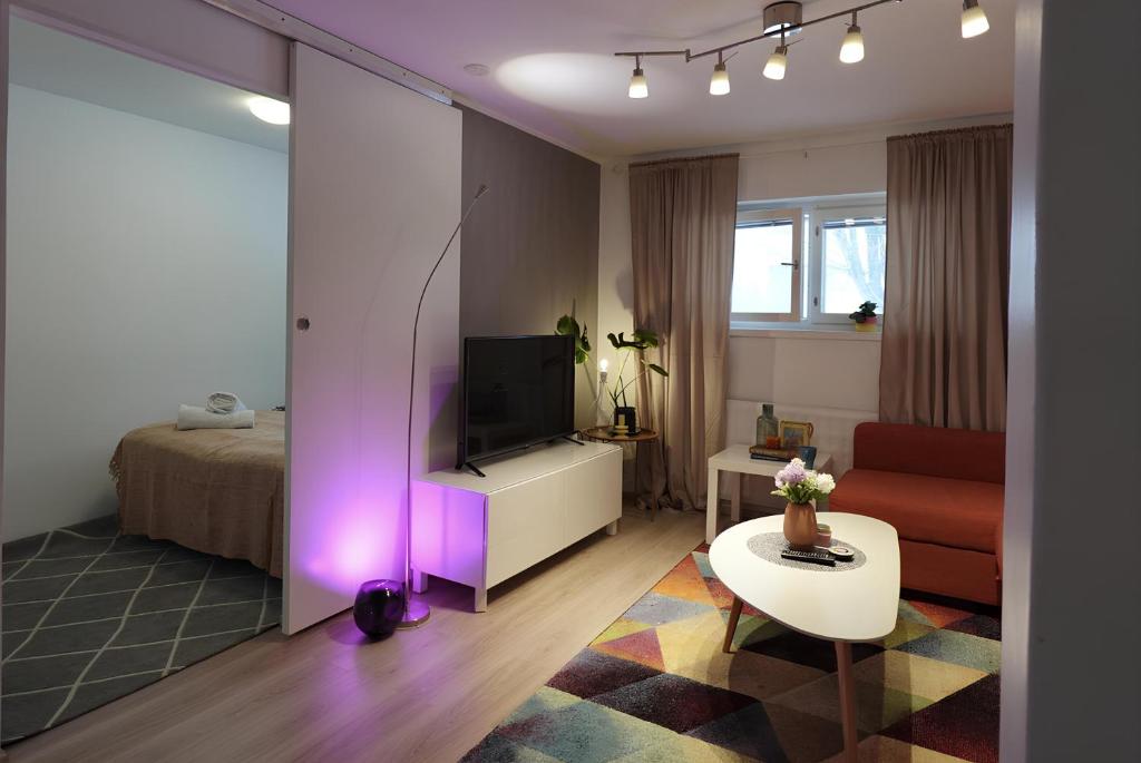uma sala de estar com televisão e um quarto com cama em Helsinki Seaside Home with Free Parking em Helsinque