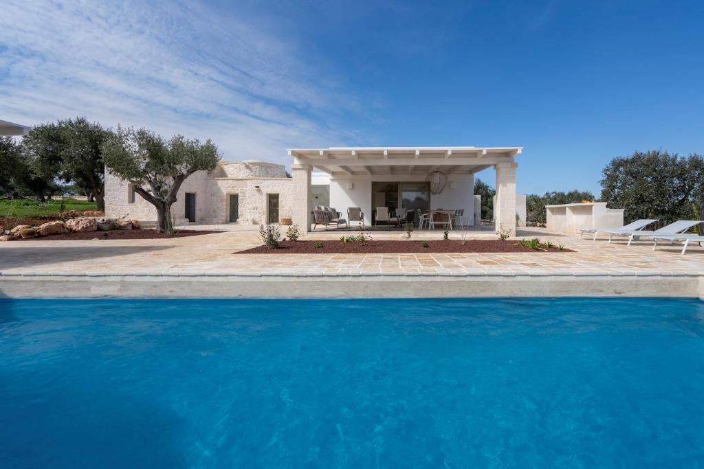 une maison avec une piscine devant une maison dans l'établissement Trullo Saraceno, à Ostuni