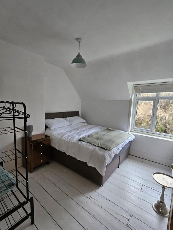 a bedroom with a bed and a table and a window at Station Cottage in Haddiscoe