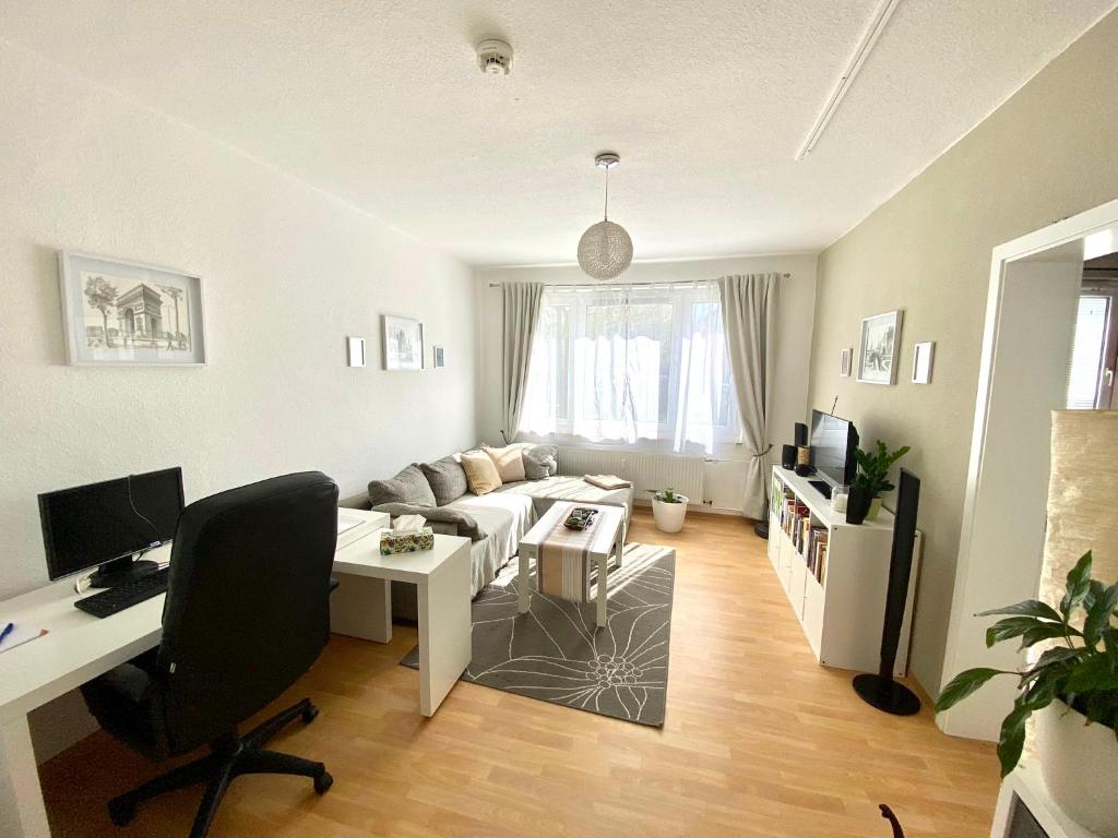 een woonkamer met een bank en een bureau bij Komplette Wohnung nahe am See in Prenzlau