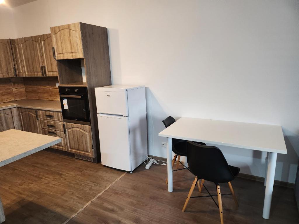uma cozinha com uma mesa branca e um frigorífico em Apartmán Topoľčany em Topoľčany