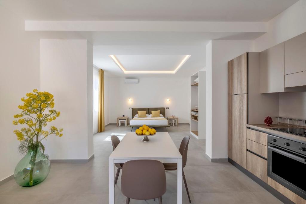 a kitchen and living room with a table and a bed at Case Vacanza Loria in Castelluzzo