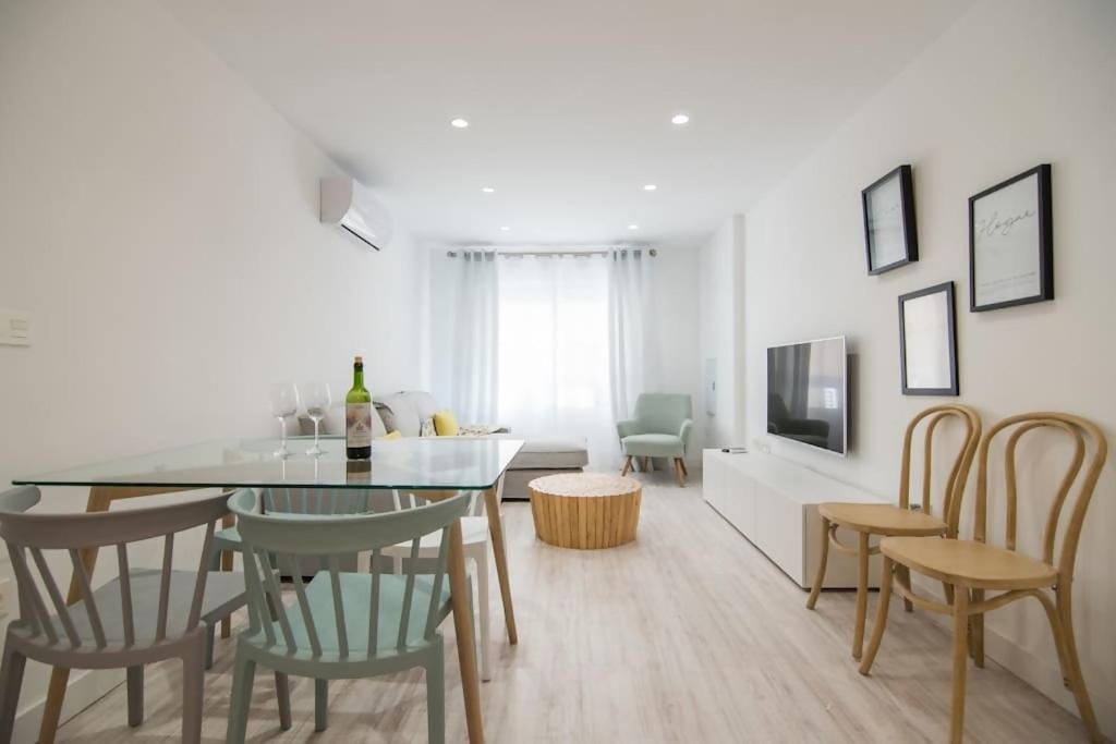a white living room with a table and chairs at Amplio y moderno apartamento en el centro de Graná in Granada