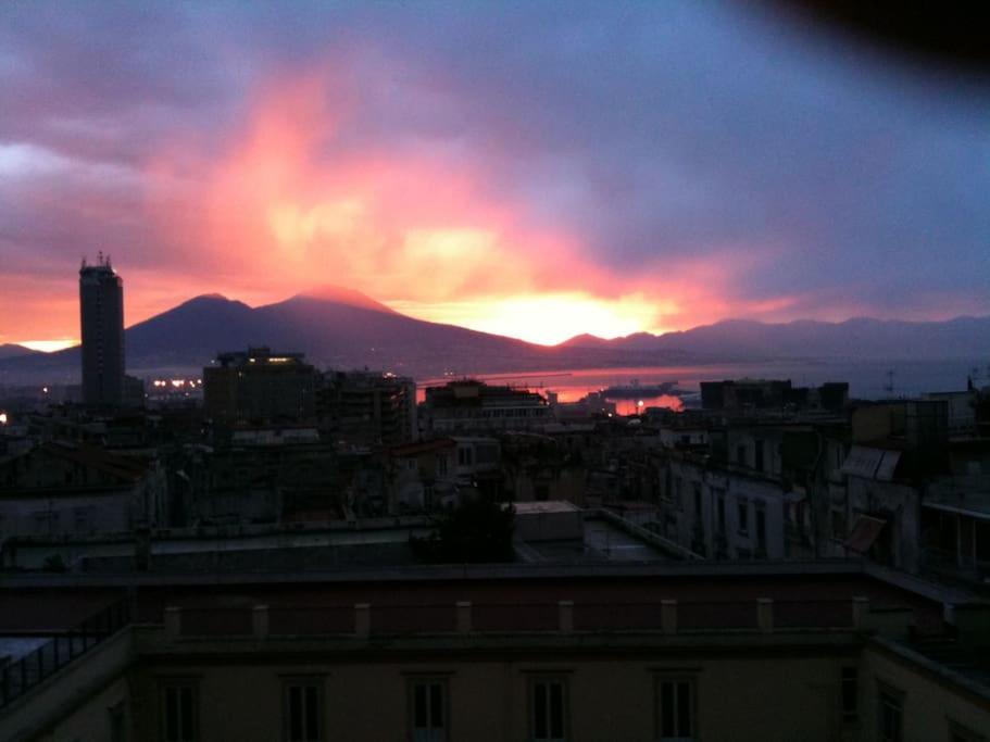- une vue sur une ville avec un coucher de soleil en arrière-plan dans l'établissement Casa Quartieri, à Naples