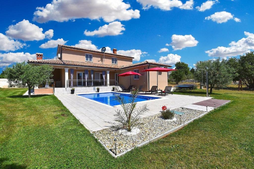 a house with a swimming pool in a yard at Ferienhaus mit Privatpool für 8 Personen ca 130 qm in Divšići, Istrien Südküste von Istrien in Divšići