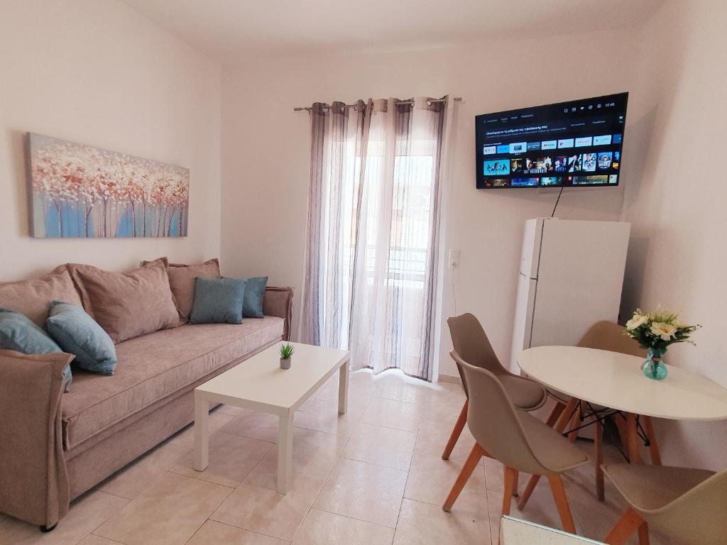 een woonkamer met een bank en een tafel bij Eva Ivoni apartments in Amoudara Herakliou