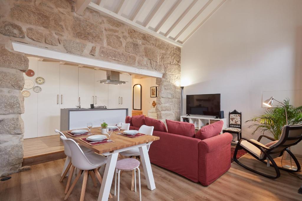 ein Wohnzimmer mit einem roten Sofa und einem Tisch in der Unterkunft Maison214 in Vila Nova de Gaia