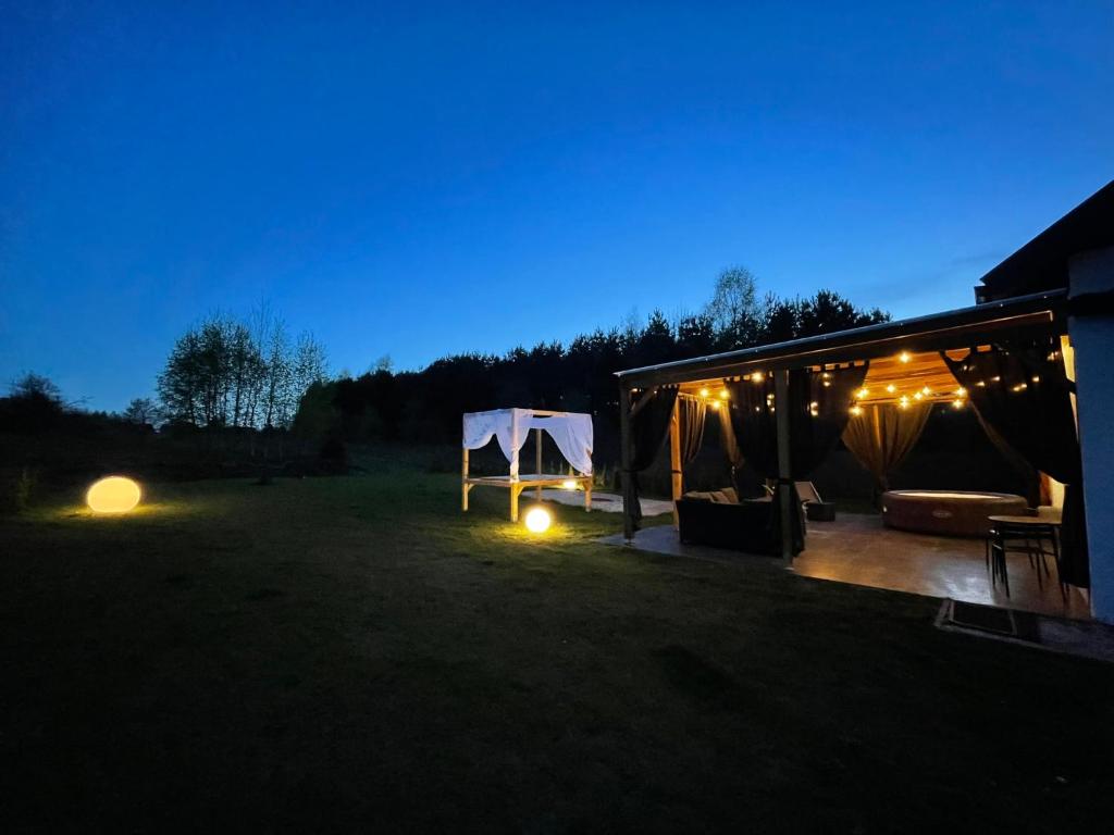 ein Zelt auf einem Feld in der Nacht mit Lichtern in der Unterkunft Domek przy lesie z basenem in Jędrzejów