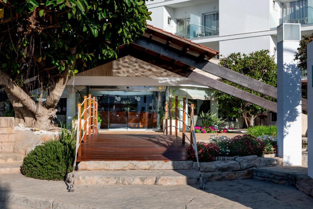 a building with a wooden walkway in front of a building at Hotel Capricho in Cala Ratjada