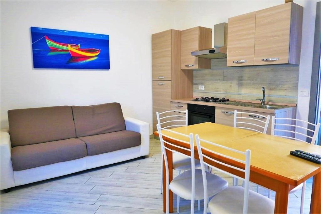 een woonkamer met een tafel en een bank in een keuken bij Ferienwohnung für 6 Personen ca 50 qm in Bibione, Adriaküste Italien Bibione und Umgebung in Bibione