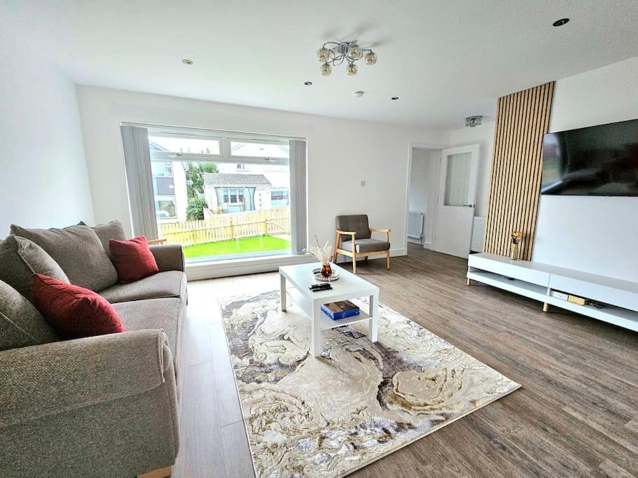 a living room with a couch and a table at Family Home with Free Parking in Newton Mearns