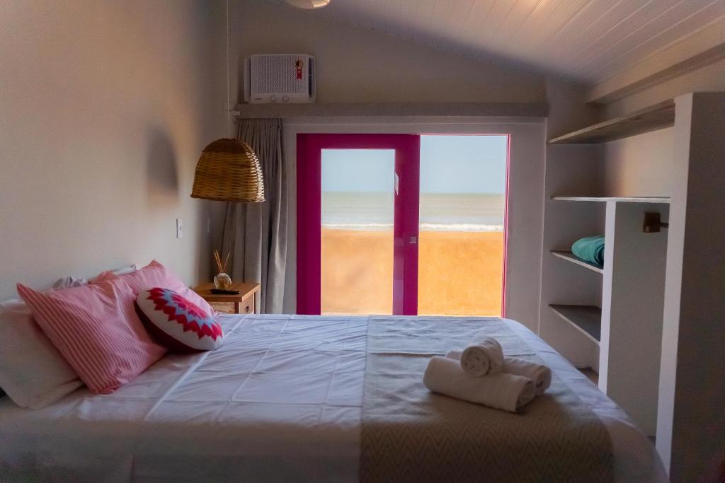 um quarto com uma cama e vista para a praia em Pousada Barari em Guarapari