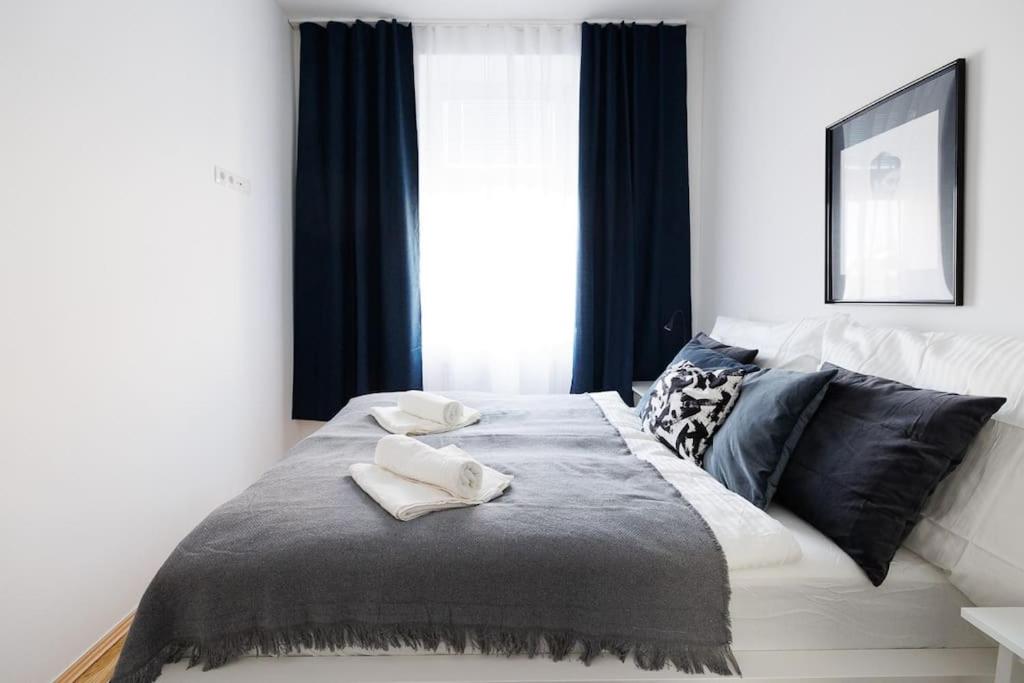 - un lit avec 2 serviettes blanches dans l'établissement Modern Apartment near City Center - 2BR, Netflix, à Vienne