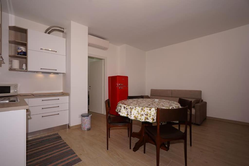 a living room with a table and a kitchen with a couch at fiordaliso 1 in Milan