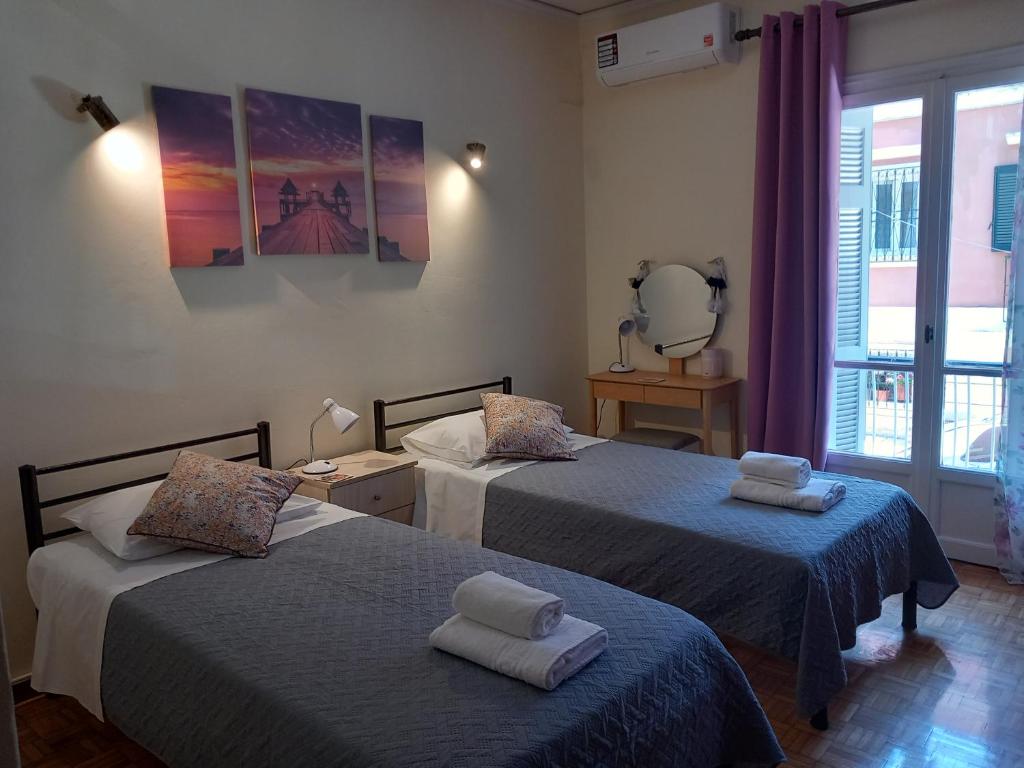 - une chambre avec 2 lits et des serviettes dans l'établissement Spiros74 Apartment in the center of Corfu Town, à Corfou