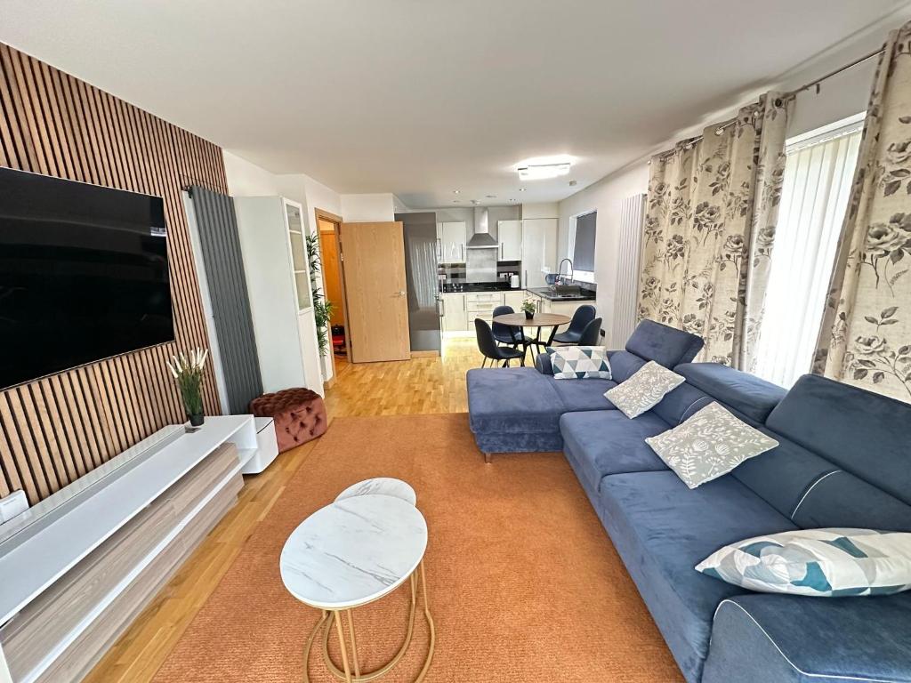 sala de estar con sofá azul y TV en little hideout en Kent