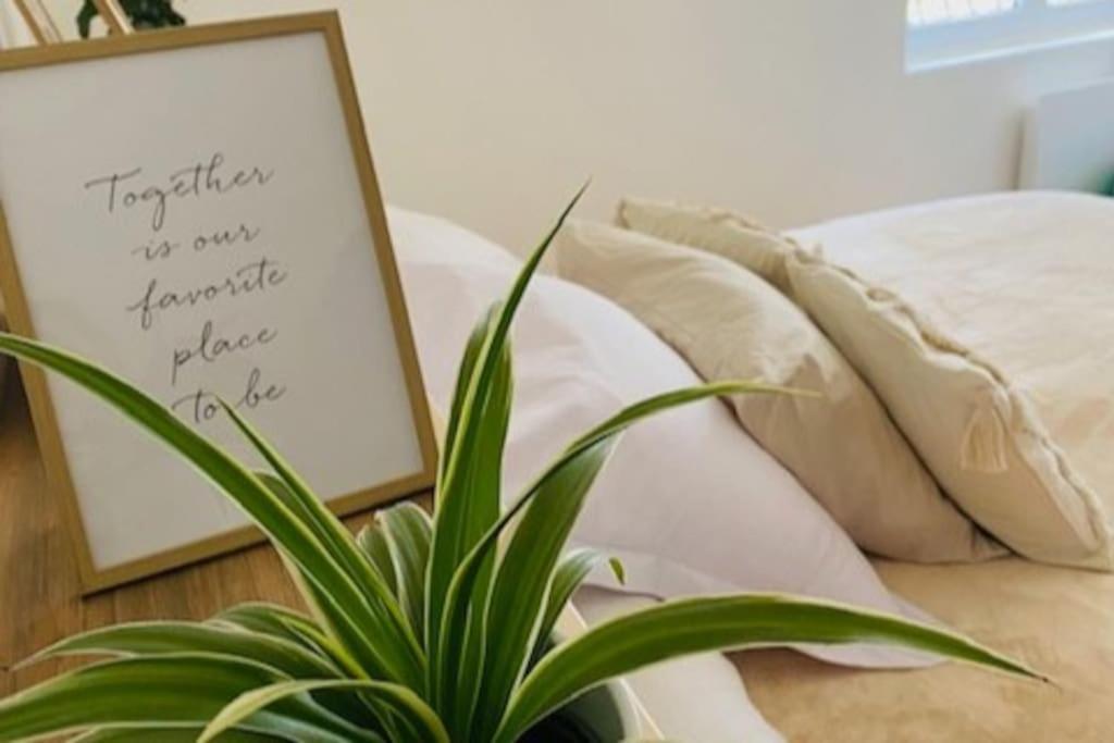 um vaso de planta sentado ao lado de uma cama com uma placa em Maison de ville avec terrasse 4 à 6 personnes em Lion-sur-Mer