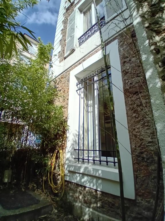 une fenêtre sur un bâtiment avec une clôture dans l'établissement Studio sur la Bièvre, à Bièvres