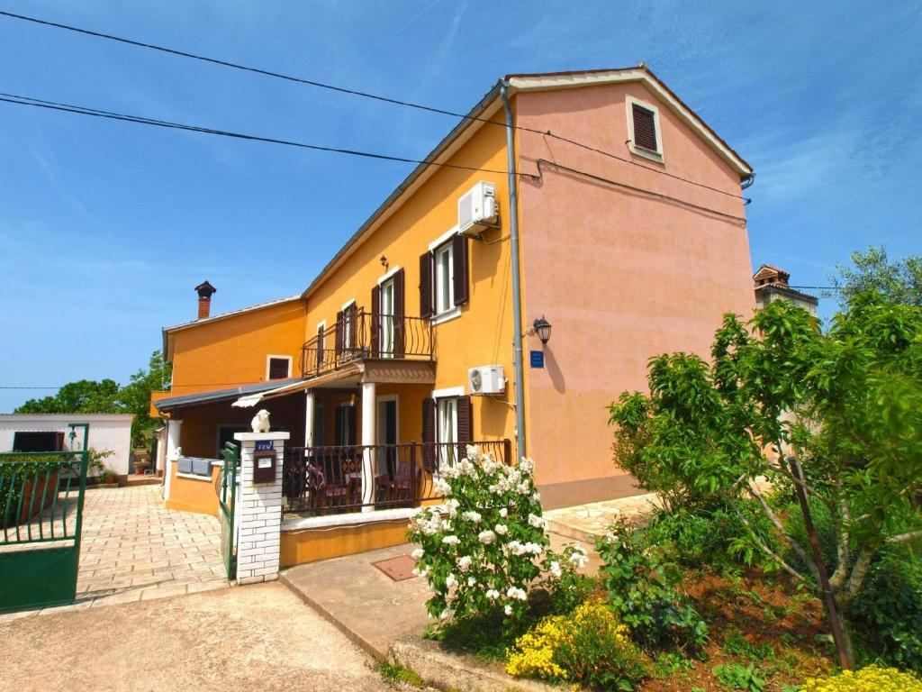 uma casa amarela e laranja com uma varanda em Ferienwohnung für 6 Personen ca 75 qm in Valtura, Istrien Südküste von Istrien em Valtura
