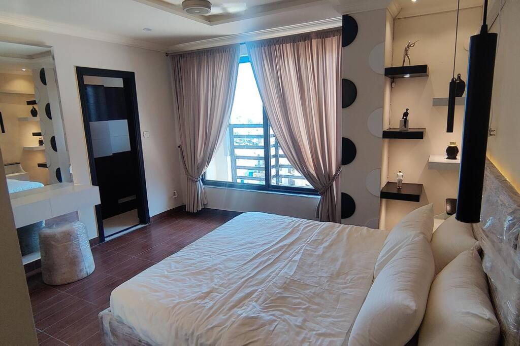 a bedroom with a large bed and a large window at Two Bedroom Designer Appartment in Rawalpindi