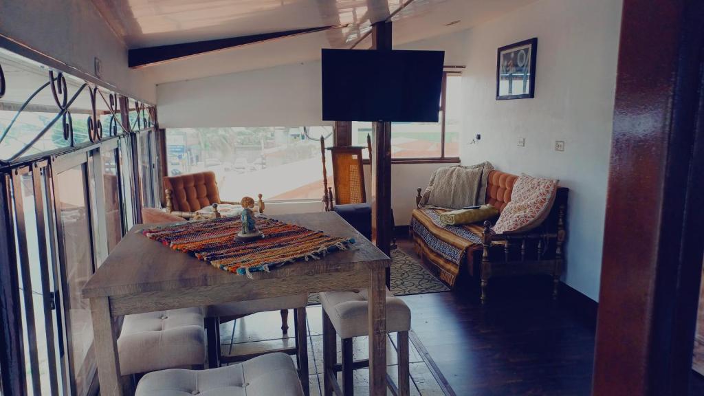 ein Wohnzimmer mit einem Holztisch und einem Sofa in der Unterkunft La posada de nana in Alajuela