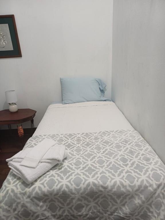 una camera da letto con un letto e un piumone bianco di La posada de nana a Alajuela