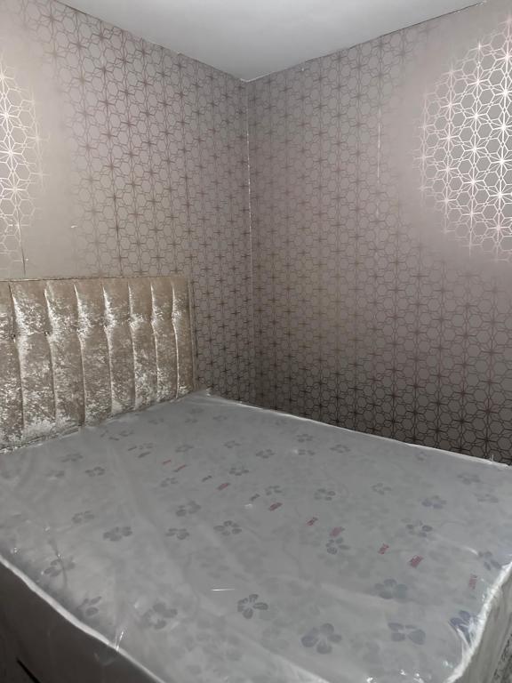 a bed in a room with a wall at Bobbys place in Barnsley