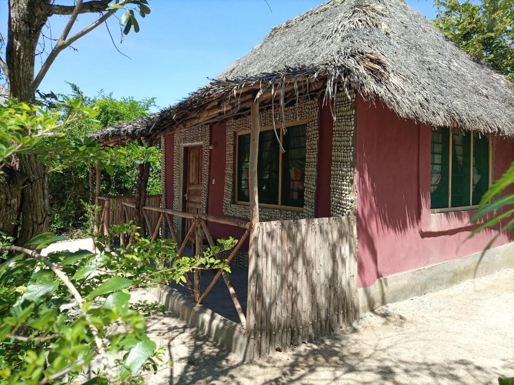a small red house with a thatched roof at Room in BB - Mida Creek Eco Camp 1 