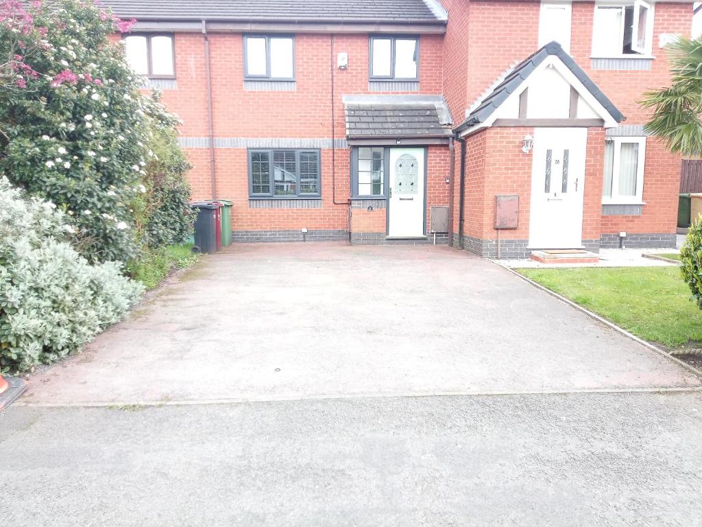 an empty driveway in front of a brick house at SEVENOAKS in Bolton