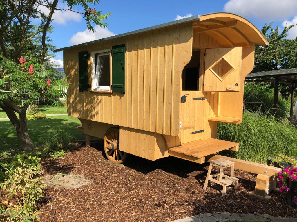 a wooden tiny house with a stool in a yard at Natur, Wasser und Land(er)leben in Bechhofen