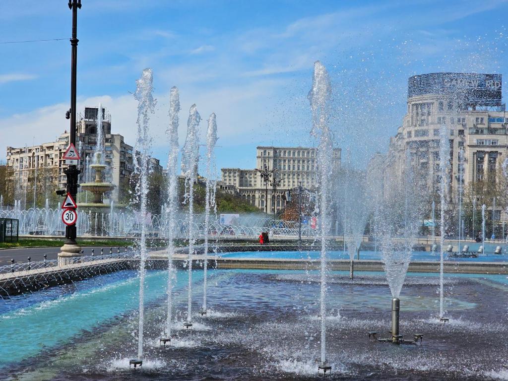 a group of water fountains in a city at Private room at Ceausescu's place in Old City Unirii Square in Bucharest