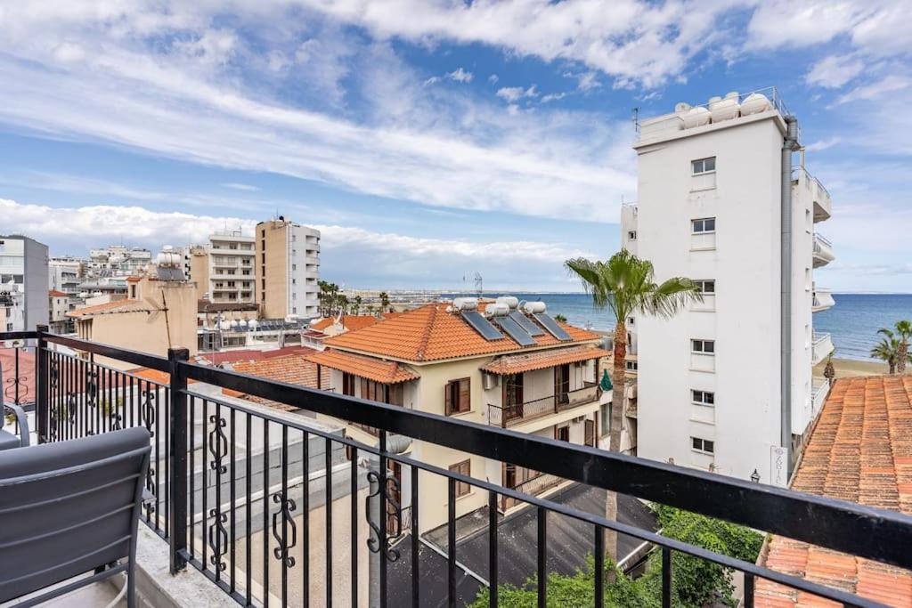 a balcony with a view of the ocean and buildings at Must Stay - Finikoudes Seaview in Larnaka
