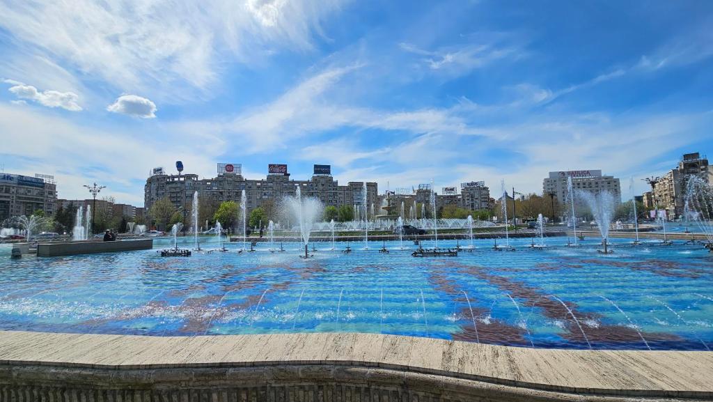 a large pool of water with fountains in a city at Private room at Ceausescu's place in Old City Unirii Square in Bucharest