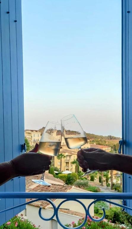 2 personnes tenant des verres à vin sur un balcon dans l'établissement Attractive Townhouse - Golf de Fregate, à Saint-Cyr-sur-Mer