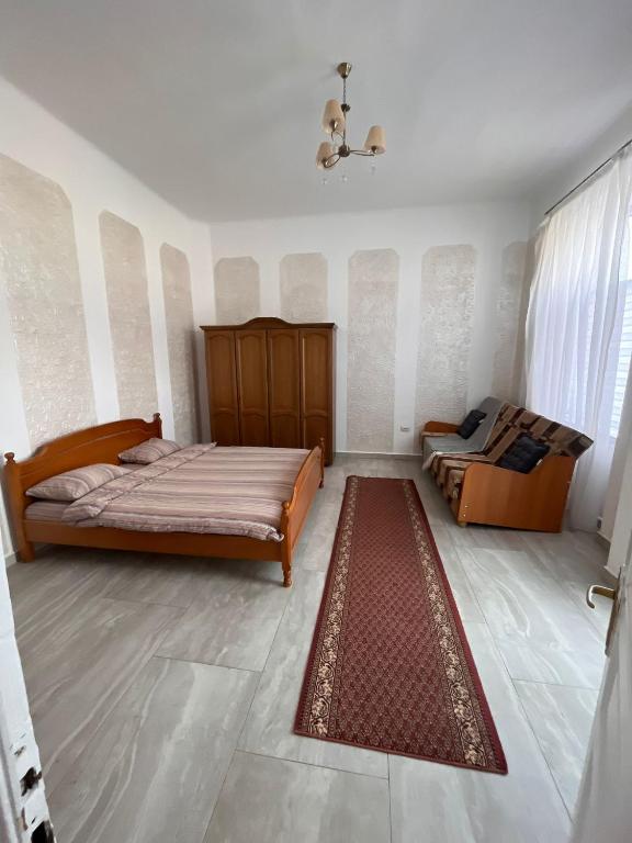 a bedroom with two beds and a rug at casa buna 1 in Rădăuţi