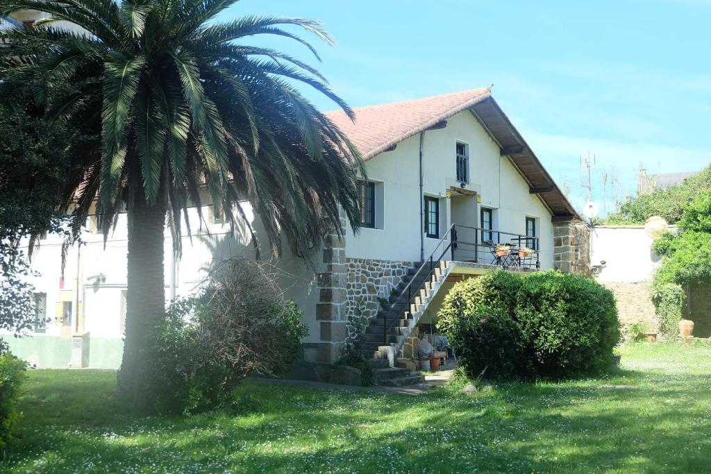 a house with a palm tree in front of it at Apto Bakio a pie de playa in Bakio