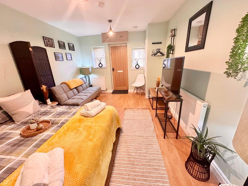 a living room with a couch and a tv at BOOT LANE STUDIO APARTMENT in Blaenavon