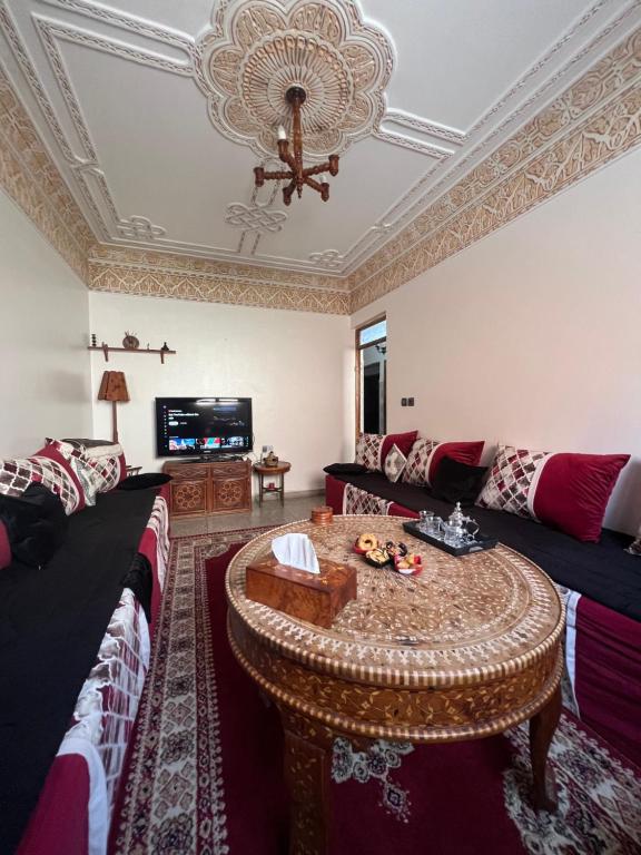 een woonkamer met een bank en een tafel bij Youss Appartement in Essaouira