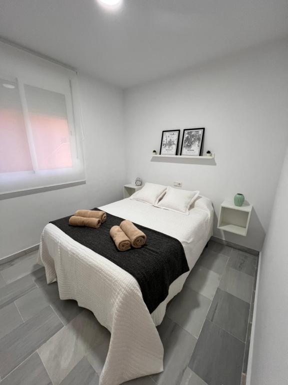ein weißes Schlafzimmer mit 2 Handtüchern auf dem Bett in der Unterkunft Apartamento Jardín de Atalaya in Camas