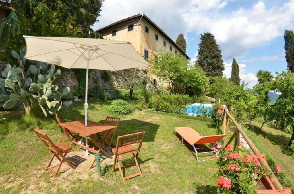 una mesa y sillas con una sombrilla en un patio en Ferienhaus mit Privatpool für 4 Personen ca 70 qm in San Gennaro, Toskana Provinz Lucca, en San Gennaro