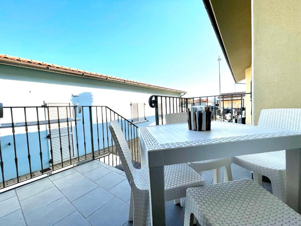 a table and chairs on a balcony with a view of the ocean at Casa Porto San Rocco in Marina di Grosseto