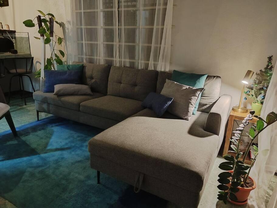 - un salon avec un canapé et un pouf dans l'établissement Hojas Verdes Rental House Excelente ubicación cerca de Campo Ferial Palmares, à Palmares