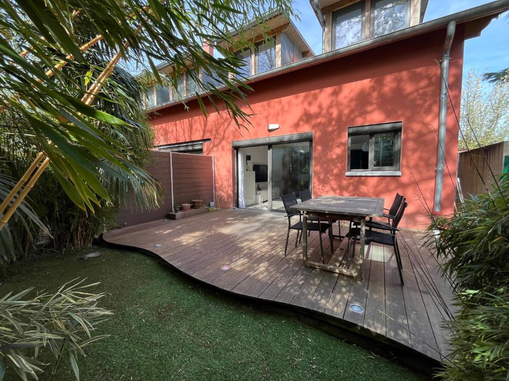 een houten terras met stoelen en een tafel voor een huis bij Sweet Home LR in Le Raincy